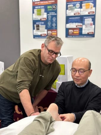 Dr Michael Chung watching a participant needle a Tung point on the ball of the foot